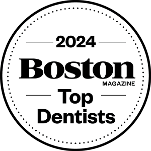 The image features a circular badge with text that reads '2021 BOSTON MAGAZINE TOP DENTISTS' in white font against a black background, indicating an accolade for dental professionals.