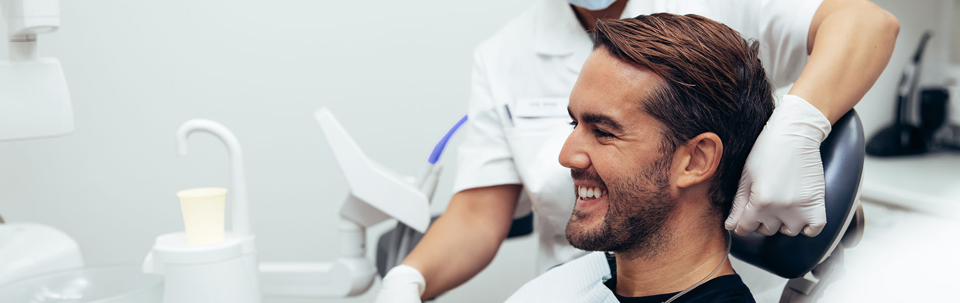 A well-lit reception area with a desk, computer monitor, and potted plant.